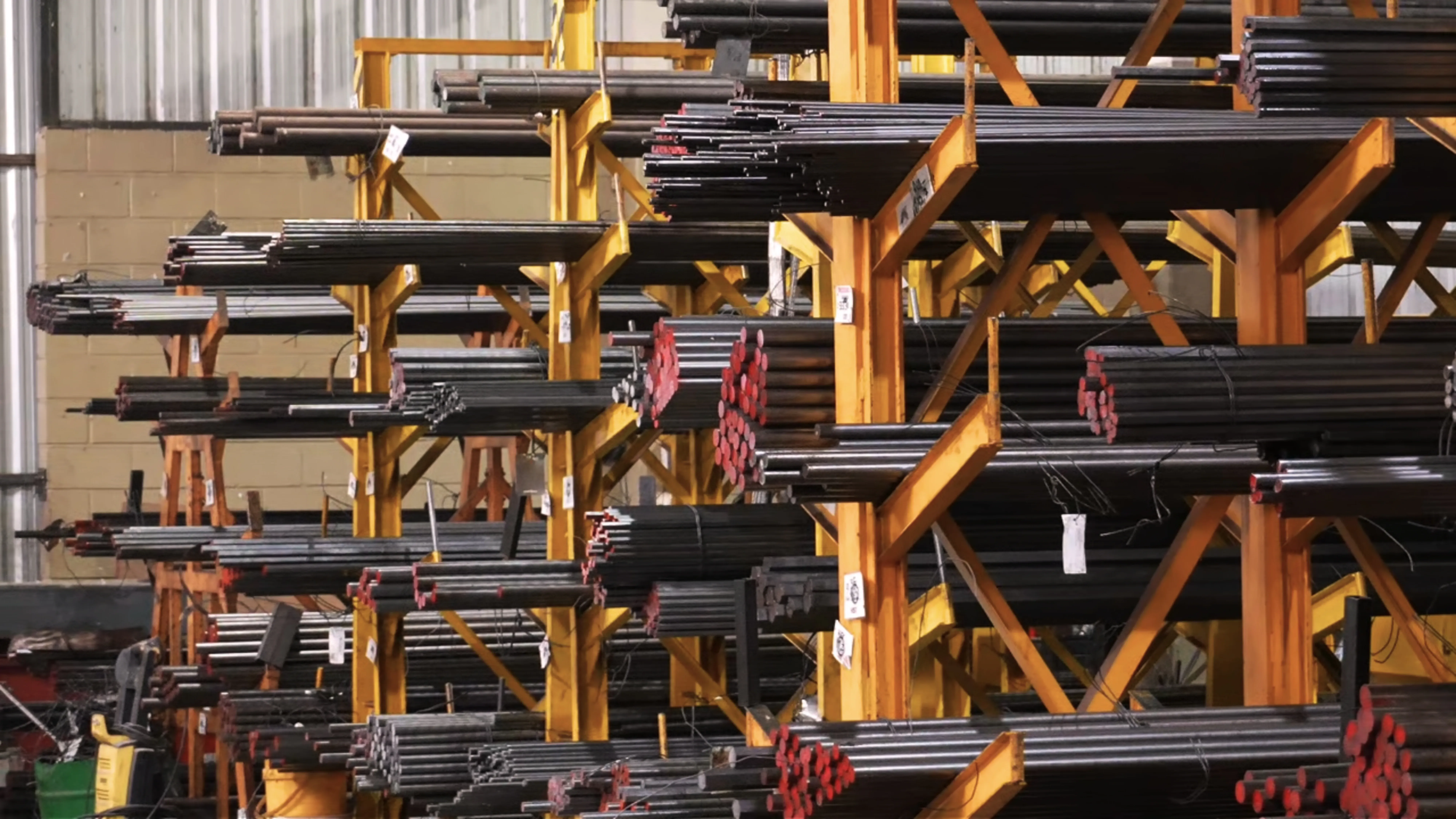 Racks con barras metálicas de materia prima en la planta de HSF